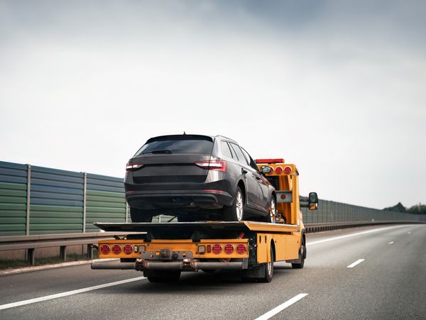 A truck transporting a car on the road