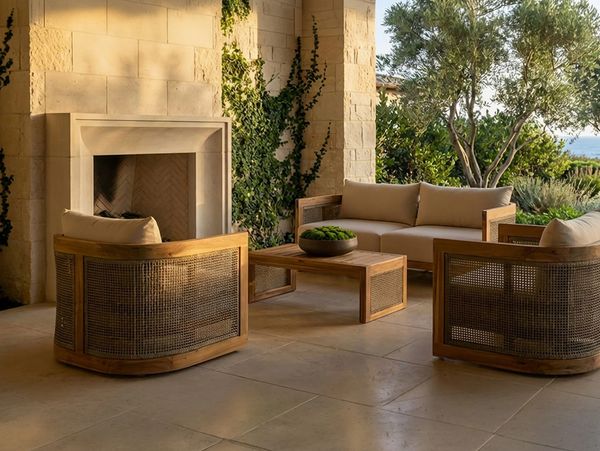 Cozy outdoor seating area with wooden furniture and a stone fireplace.