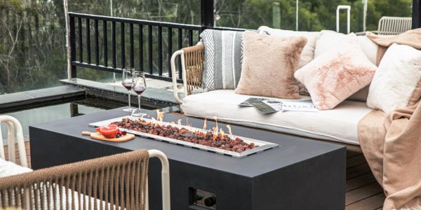 Cozy outdoor seating area with fire pit table and wine glasses.