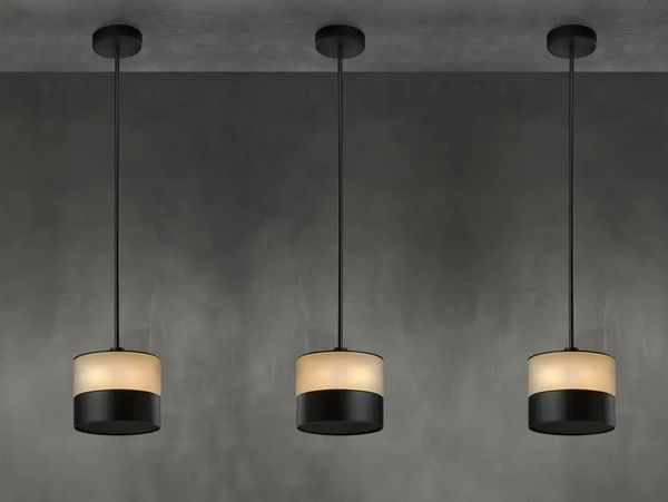 Three modern pendant lights with black and cream shades hanging from the ceiling.