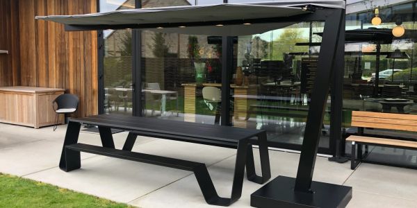 Modern black outdoor bench with attached canopy for shade.