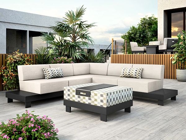 Modern outdoor patio with beige sectional sofa and patterned ottoman.