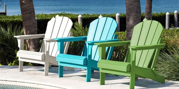 Three colorful Adirondack chairs by the waterfront pool.