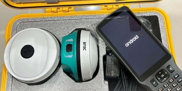 Surveying equipment including GPS devices and an Android handheld unit in a protective case.