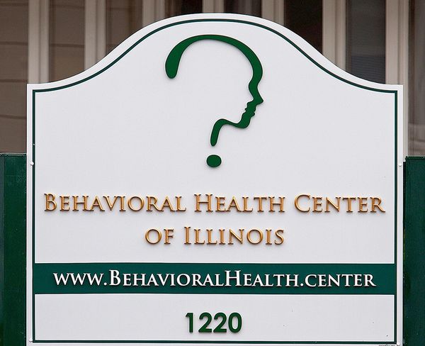 Sign for Behavioral Health Center of Illinois with a question mark and face logo.