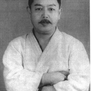 Black and white portrait of a man with folded arms.