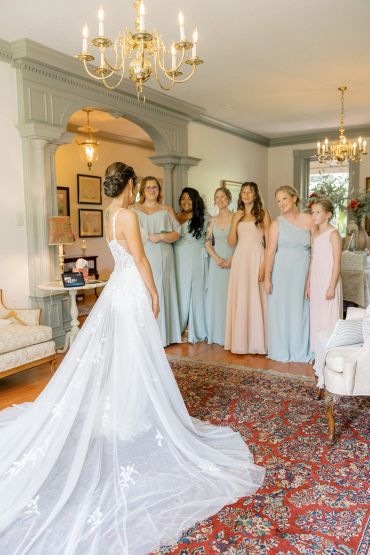 Bride showing her dress to bridesmaids.