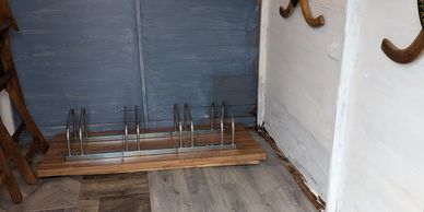Bike shed wall with vintage hockey sticks and organised storage space at Snowberry Cottage.