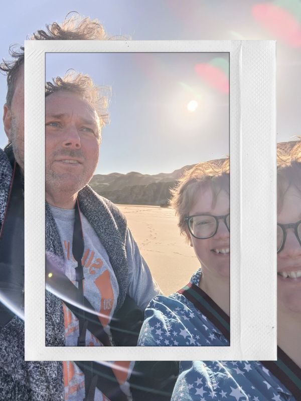 Picture of Beverley and Alastair on a beach, sun behind