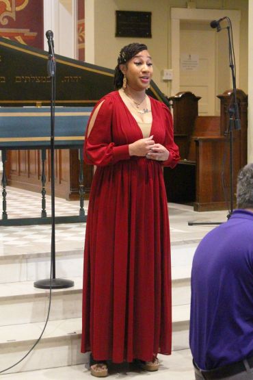 Woman singing in a red dress.