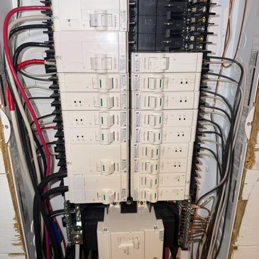 Close-up of a home electrical breaker panel with circuit breakers and wiring.
