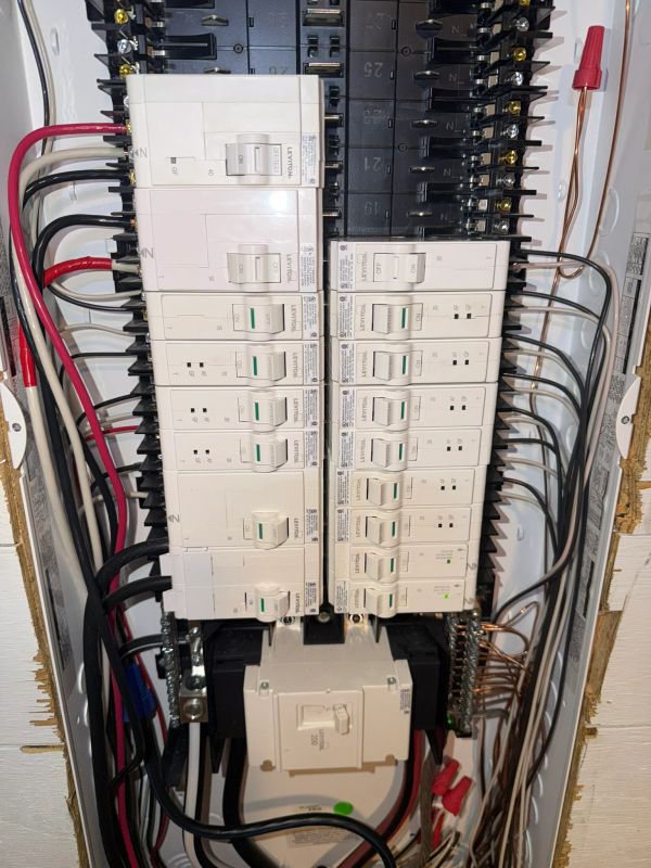 Electrical panel with circuit breakers and organized wiring.