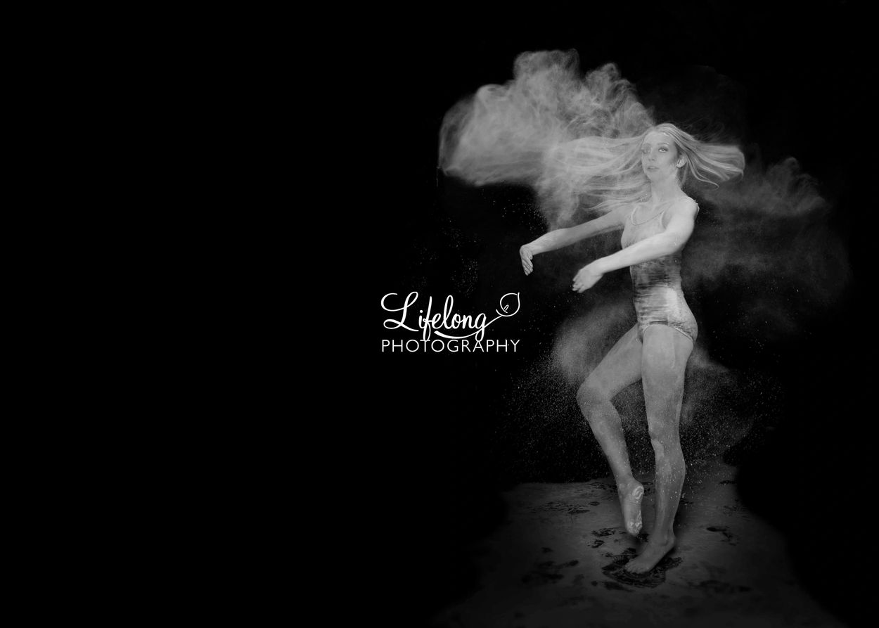 Lifelong Photography. Creative studio portrait of female ballet dancer twirling (powder for drama)