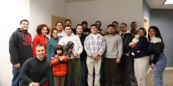 Group photo of diverse people indoors.