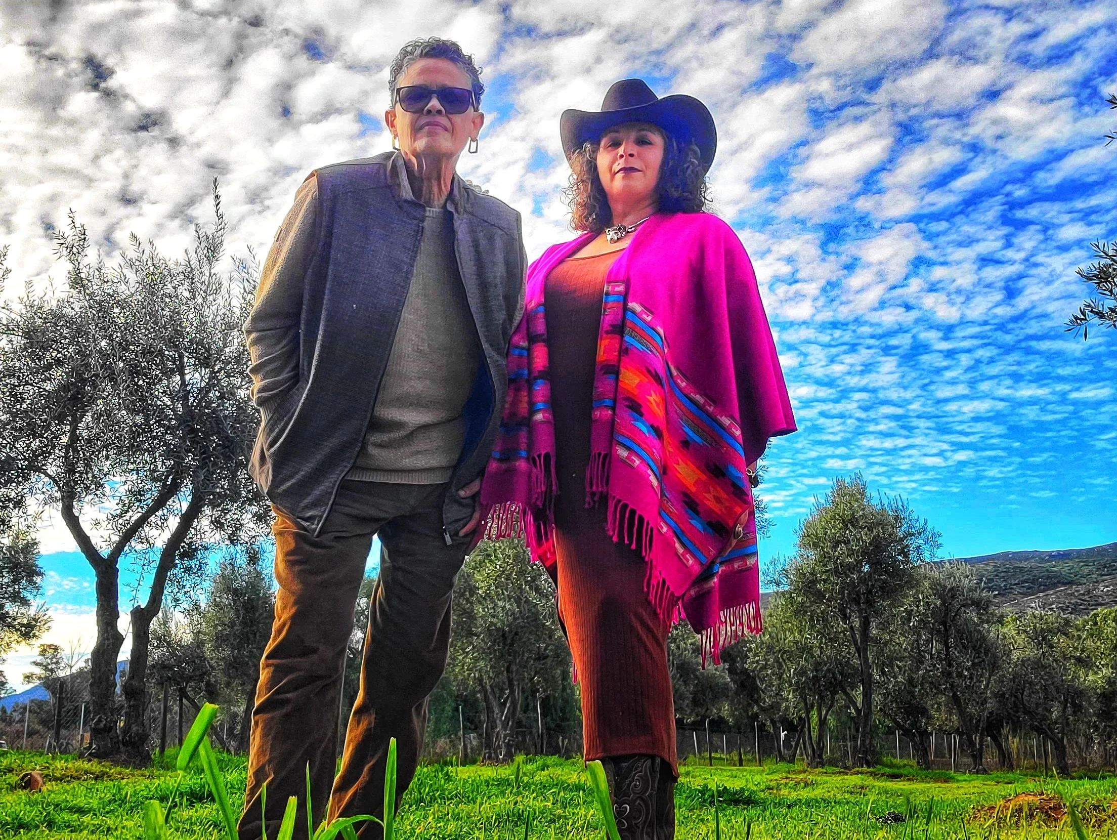 Two people standing outdoors under a cloudy sky.