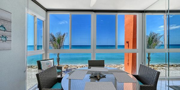 Cozy dining area with ocean view through large windows.