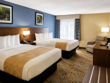 Hotel room with two beds and cozy lighting.