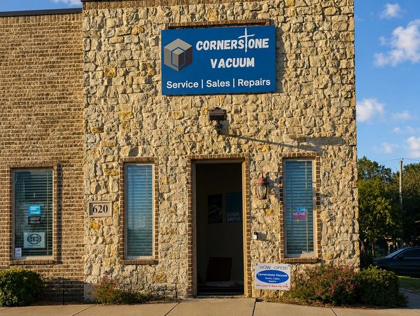 Stone building with Cornerstone Vacuum sign offering service, sales, and repairs.