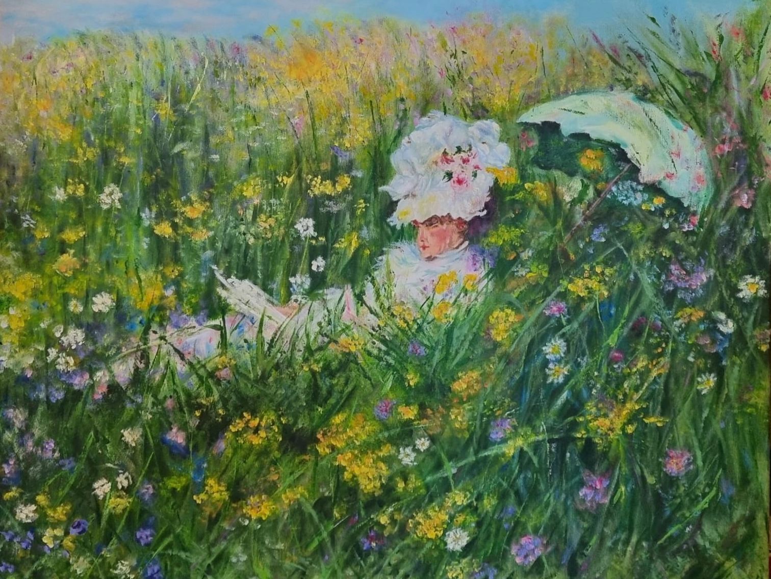 Woman in white dress and hat reading in a colorful flower field with a parasol.