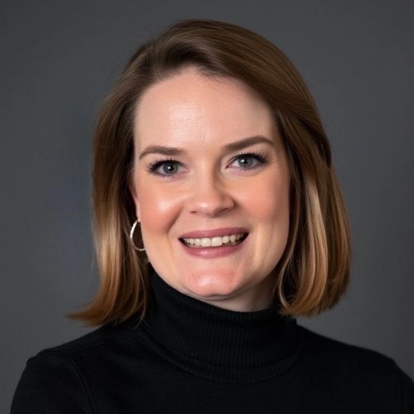 Smiling woman with shoulder-length hair and hoop earrings.