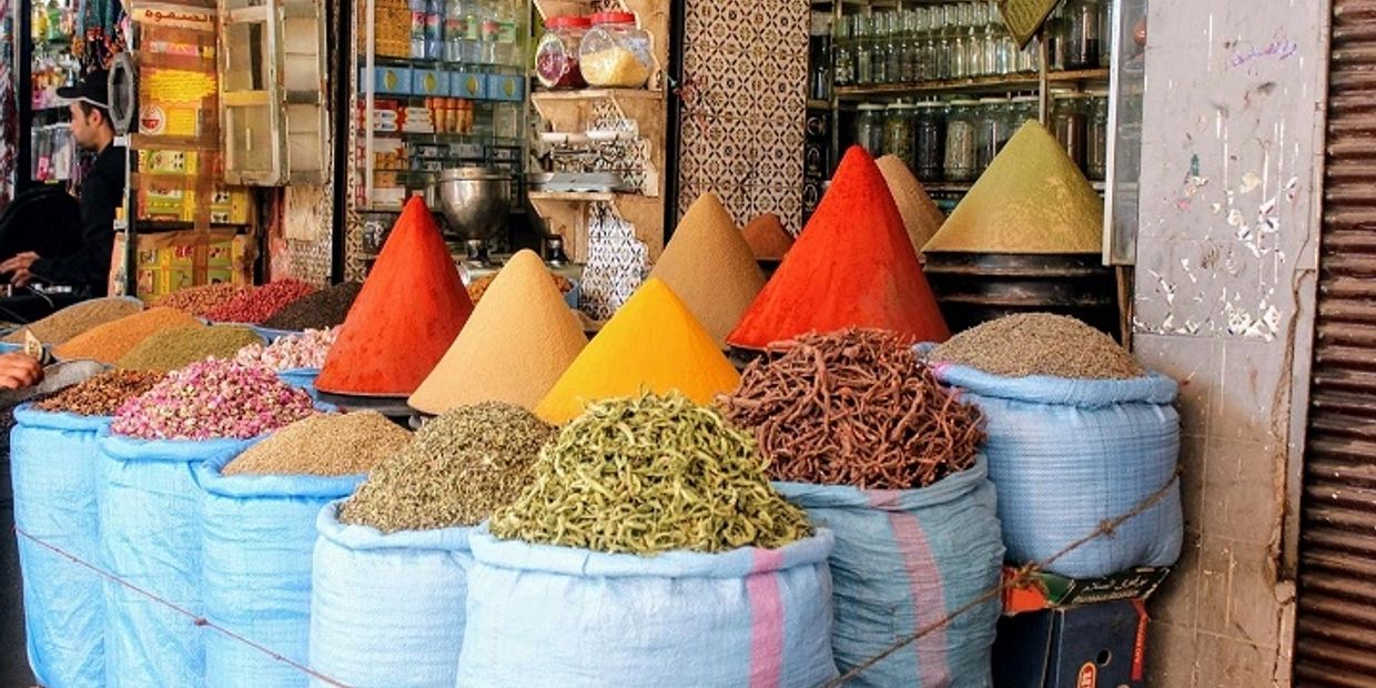 Colorful spices and herbs displayed in large sacks at a market stall.