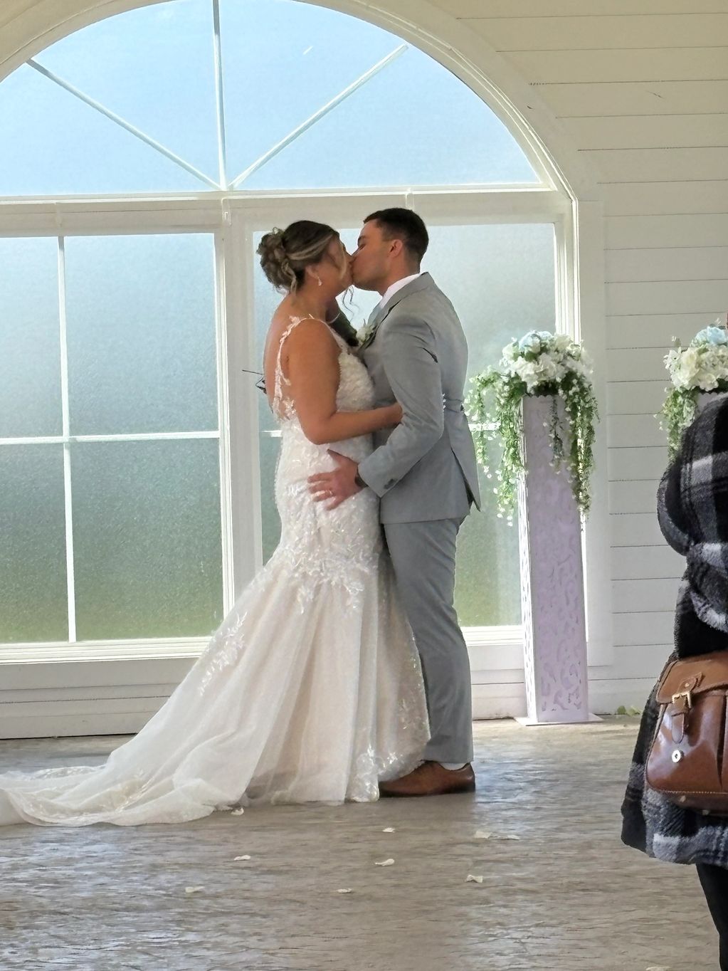 Bride and groom sharing a kiss during their wedding ceremony.