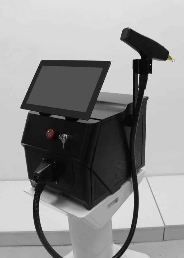 A black laser machine with a touchscreen on a white stand.