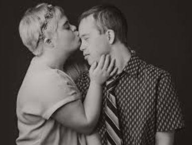 Woman with Down Syndrome Kisses a man with Down Syndrome on the forehead. PHOTO: HILARY GAULD