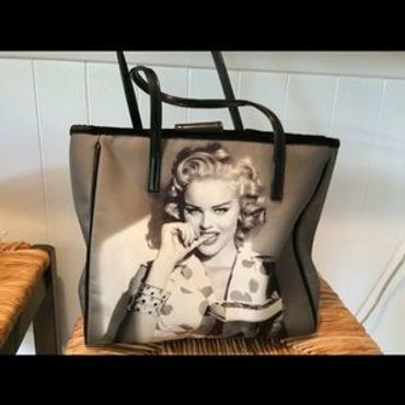 Guess purse with black and white images on both sides (possibly of Anna Nicole Smith).