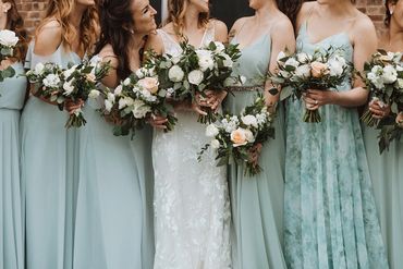 blue bridesmaids dresses and white and peach bouquets