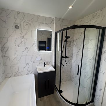 Modern bathroom with shower, sink, and bathtub.