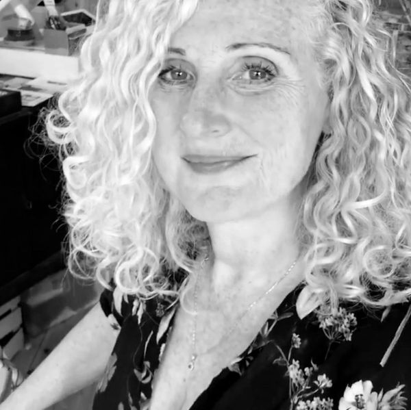 Black and white portrait of a smiling woman with curly hair.