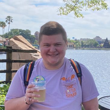 Mars Graves standing in Epcot in front of Lagoon holding beverage.