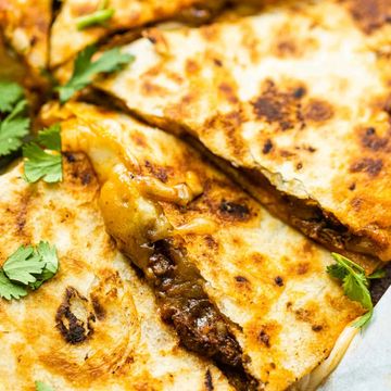 Close-up of cheesy beef quesadillas garnished with cilantro.