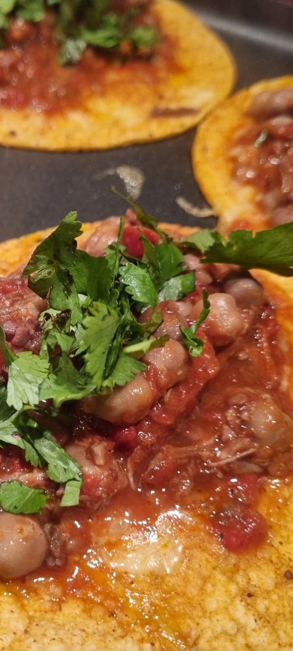 Tostadas topped with beans, salsa, and fresh cilantro.