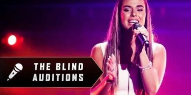 Young woman singing during The Blind Auditions with a microphone.