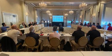 People attending a formal meeting in a luxurious conference room.