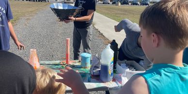 Children engaging in a hands-on science activity outdoors.