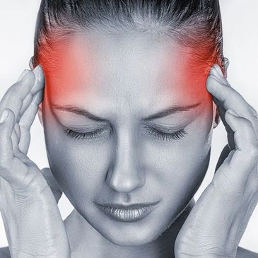 Black/white photo of a woman in pain. There is red at her temples to show a headache or migraine.