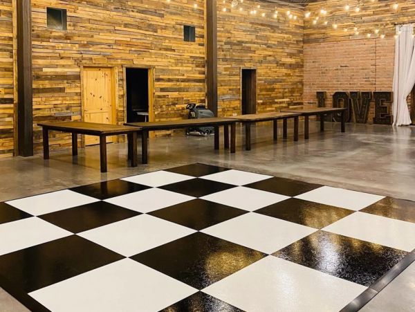 Spacious room with wooden walls and checkered floor.