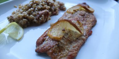 A plate with grilled trout and wild rice.