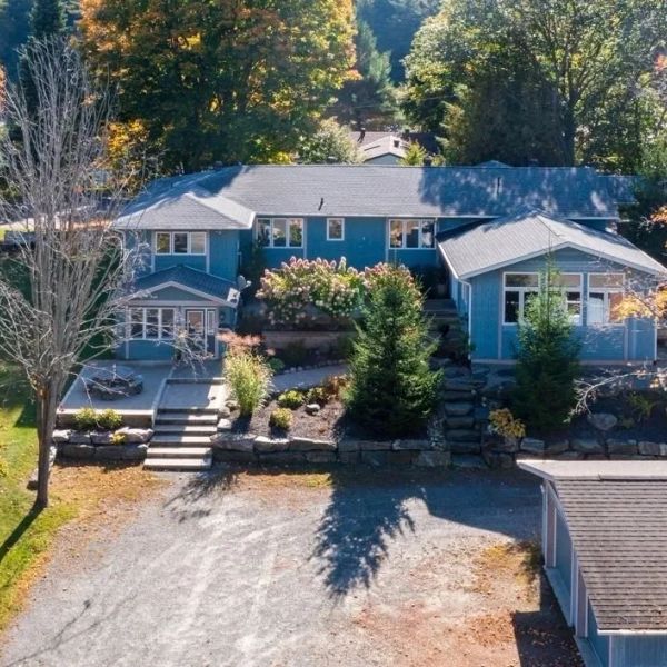 Blue house surrounded by trees and garden in autumn.