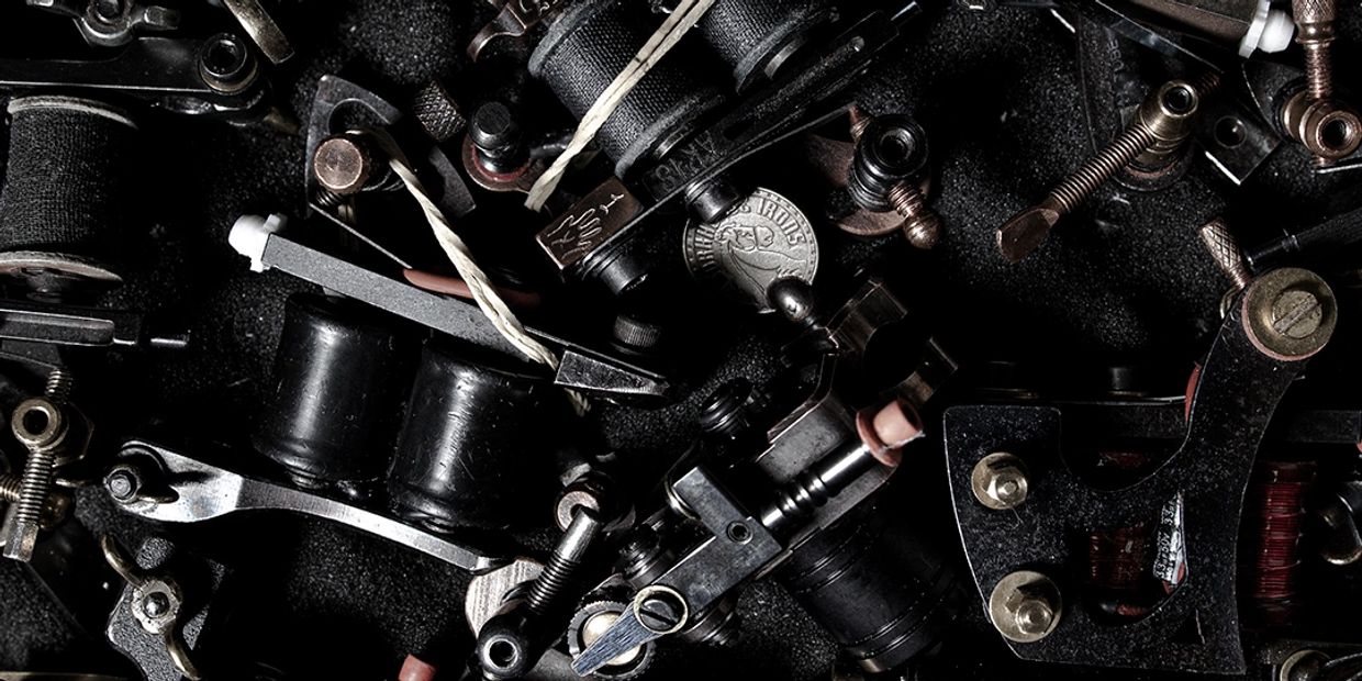 Close-up of various tattoo machine parts arranged closely together.