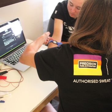 Person using a laptop and wearing a branded t-shirt.