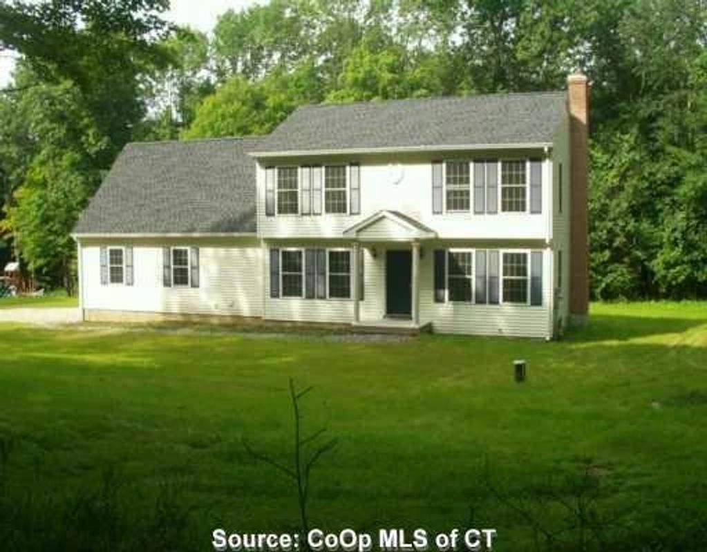 Two-story suburban house with white siding and gray shutters.