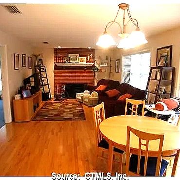 Dining room into the living room, hardwood floors and a custom brick fireplace with a flush hearth