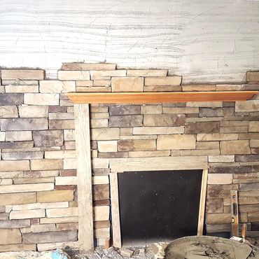 Culture stone installation with wood mantle