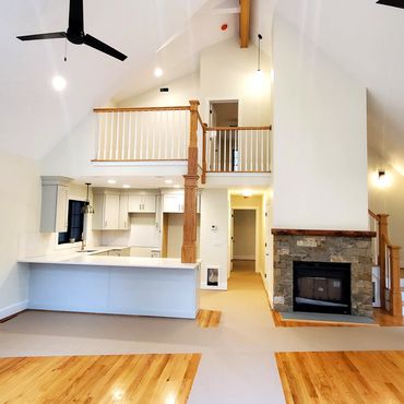 View of balcony above and hallway leading to a 1st floor master bedroom.
A cathedral ceiling with an