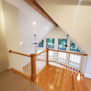 View looking down from balcony, hardwood flooring, posts and hand railings