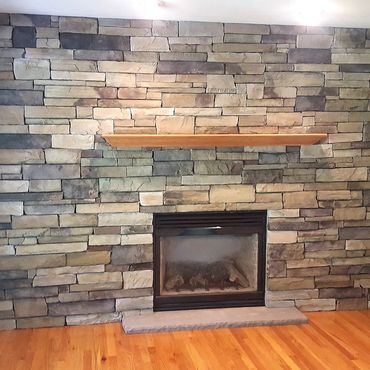 Finished cultured stone veneer with a wood mantle and brownstone hearth